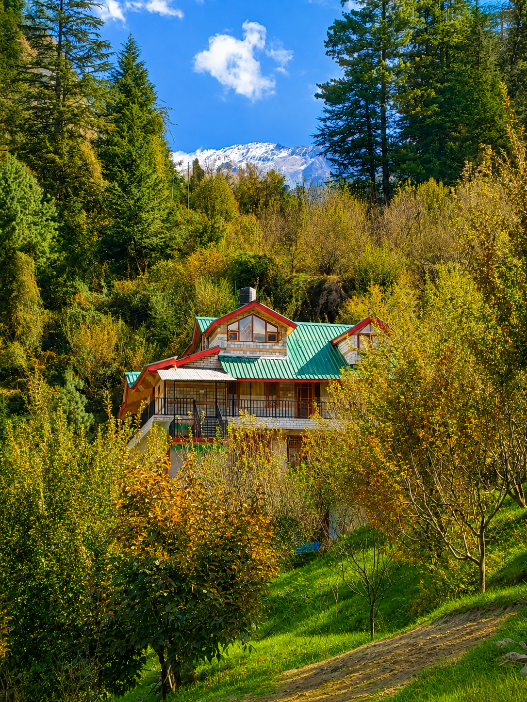Heavens Orchard nestled among the orchard with a snow-capped Himalayan ridge behind